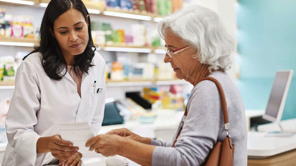 Pharmacist speaking with older woman