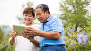 Smiling senior couple using digital tablet in a park
